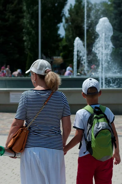 Vrouw met een jongen in de buurt van de fontein — Stockfoto