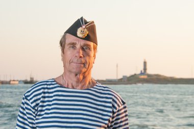 garrison kap ve çizgili yelek arka planda duran adam