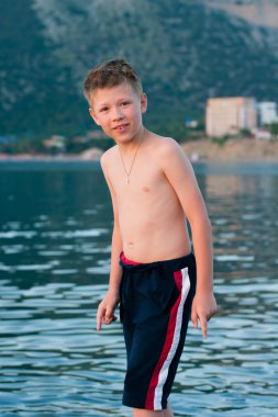 Çocuk deniz ve dağlar bir arka plan üzerinde