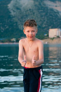 Çocuk deniz ve dağlar bir arka plan üzerinde