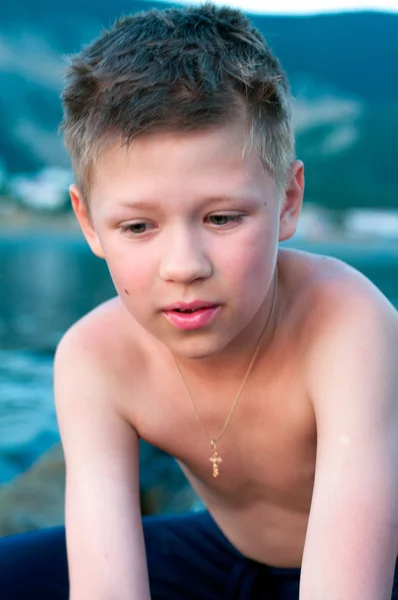 Мальчик на фоне моря и гор — стоковое фото