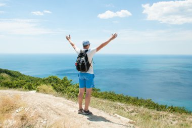 Erkek bir dağın tepesinde eller