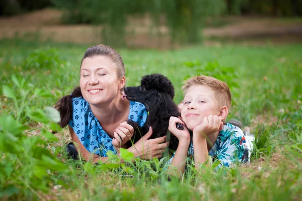 Moeder met zoon en een zwarte poedel — Stockfoto