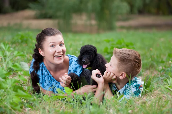 Mãe com filho e um poodle preto — Fotografia de Stock