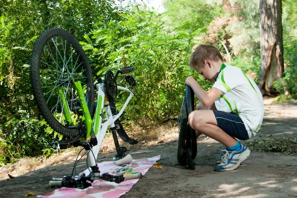 Jongen die herstellen van een fietswiel — Stockfoto