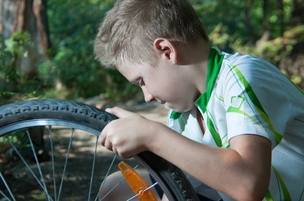 Jongen die herstellen van een fietswiel — Stockfoto