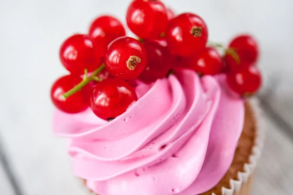 Cupcakes con crema rosa y grosella roja — Foto de Stock