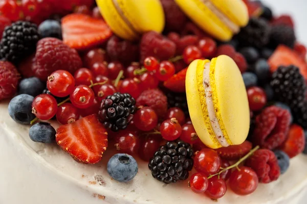 Pastel blanco con frutas y makarons — Foto de Stock