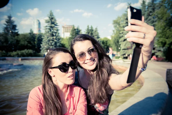 Twee jonge vrouwen nemen een selfie buiten — Stockfoto