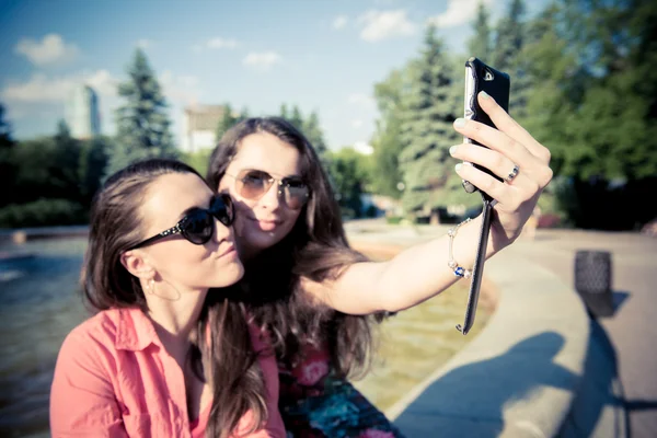 Duas jovens mulheres tirando uma selfie ao ar livre — Fotografia de Stock