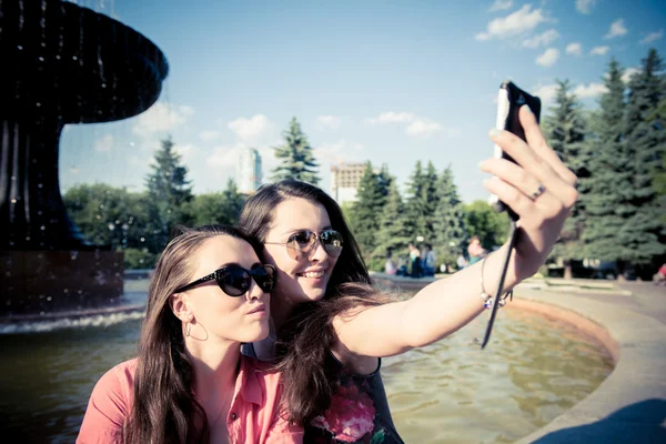 Duas jovens mulheres tirando uma selfie ao ar livre — Fotografia de Stock