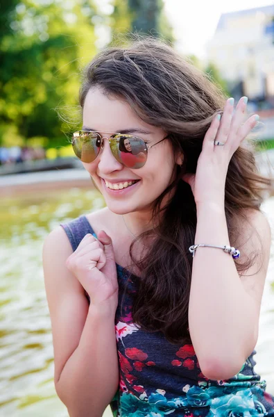 Mujer joven sonriente al aire libre en gafas de sol —  Fotos de Stock