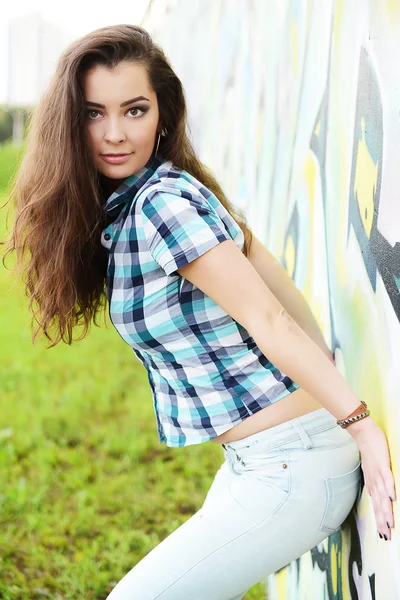 Retrato de una joven sentada en la pared de graffiti —  Fotos de Stock