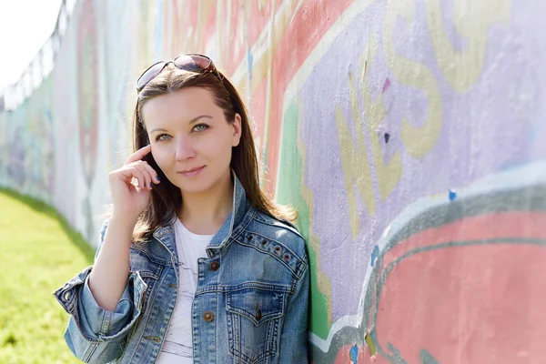 Chica en gafas de sol cerca de la pared de graffiti —  Fotos de Stock