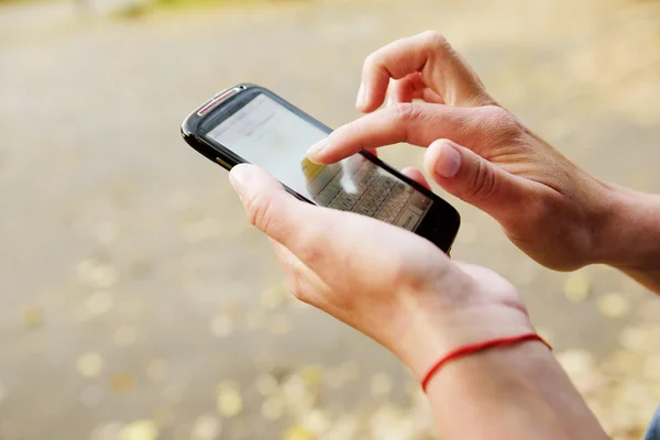 Woman using smart phone outside Stock Picture