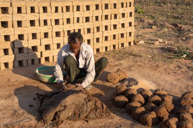 TIKAMGARH, MADHYA PRADESH, INDIA - 11 AĞUSTOS 2021: Kalıplı ve ıslak kilden ev tuğlaları yapan Hintli adam.