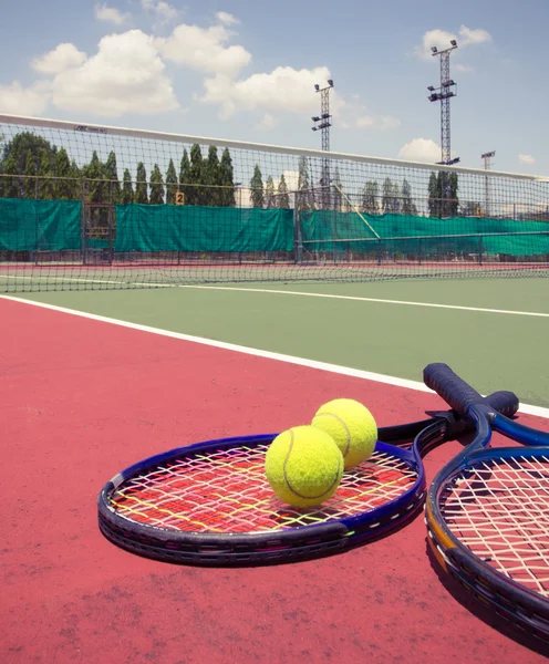 Tennis racket with balls on tennis court — Stock Photo, Image