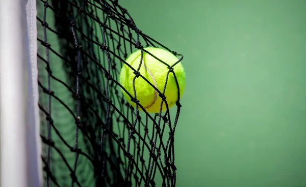 Tennis ball in net — Stock Photo, Image