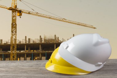 ahşap masa üzerinde güvenlik kask ve mimar bitki