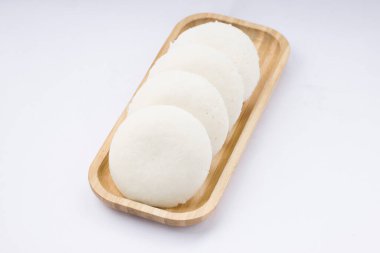 Idly ya da Idli, Güney Hindistan 'ın ana kahvaltı öğesi. Beyaz arka plana yerleştirilmiş, harika bir şekilde yerleştirilmiş..