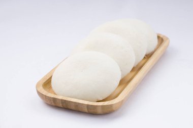 Idly ya da Idli, Güney Hindistan 'ın ana kahvaltı öğesi. Beyaz arka plana yerleştirilmiş, harika bir şekilde yerleştirilmiş..