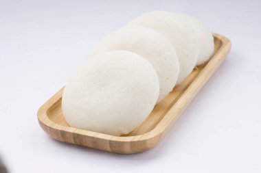 Idly ya da Idli, Güney Hindistan 'ın ana kahvaltı öğesi. Beyaz arka plana yerleştirilmiş, harika bir şekilde yerleştirilmiş..