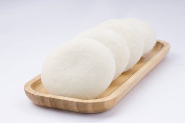 Idly ya da Idli, Güney Hindistan 'ın ana kahvaltı öğesi. Beyaz arka plana yerleştirilmiş, harika bir şekilde yerleştirilmiş..