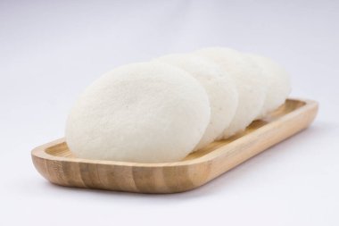 Idly ya da Idli, Güney Hindistan 'ın ana kahvaltı öğesi. Beyaz arka plana yerleştirilmiş, harika bir şekilde yerleştirilmiş..