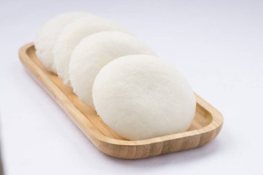 Idly ya da Idli, Güney Hindistan 'ın ana kahvaltı öğesi. Beyaz arka plana yerleştirilmiş, harika bir şekilde yerleştirilmiş..