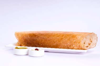 Dosa _ Ghee rosto Dosa, ünlü Güney Hindistan kahvaltı öğesi geleneksel yöntemle kast demir tavasından yapılır ve beyaz arka planda beyaz bir tabakta servis edilir..