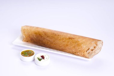 Dosa _ Ghee rosto Dosa, ünlü Güney Hindistan kahvaltı öğesi geleneksel yöntemle kast demir tavasından yapılır ve beyaz arka planda beyaz bir tabakta servis edilir..