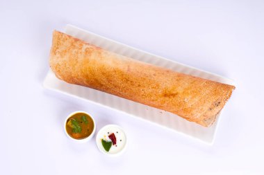 Dosa _ Ghee rosto Dosa, ünlü Güney Hindistan kahvaltı öğesi geleneksel yöntemle kast demir tavasından yapılır ve beyaz arka planda beyaz bir tabakta servis edilir..