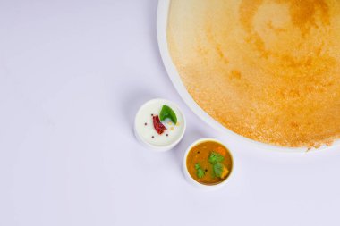 Dosa _ Ghee rosto Dosa, ünlü Güney Hindistan kahvaltı öğesi geleneksel yöntemle kast demir tavasından yapılır ve beyaz arka planda beyaz bir tabakla servis edilir..
