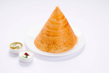 Dosa _, Ghee rosto Dosa, ünlü Güney Hindistan kahvaltı öğesi geleneksel olarak kast demir tavasından yapılır ve beyaz bir arka planda sambar ve hindistan cevizi turşusuyla izole edilmiş beyaz bir tabakta düzenlenir..