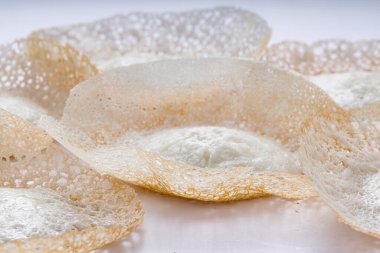 Appam veya velliappam veya kallappam veya paalappam, Güney Hindistan veya malabar bölgesinde lezzetli kahvaltı öğesi, çiğ pirinç kullanılarak yapılır ve sebze ve sebze olmayan köriler için iyi bir kombinasyon, beyaz bir arka plana yerleştirilir..