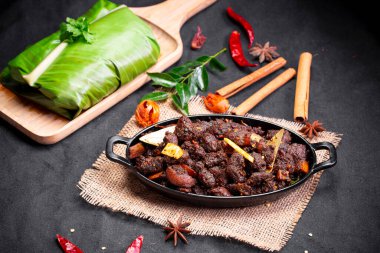 Sığır rostosu ya da pothu ulareyadu, kerala özel yemeği siyah bir masa takımında ve muz yaprağında geleneksel olarak siyah bir arkaplana yerleştirilir..