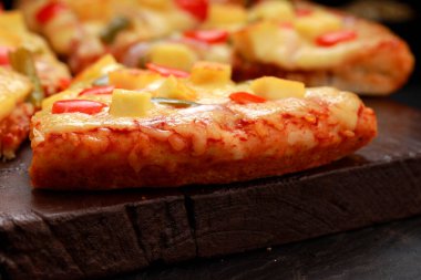 Pizza _ Paneer Makhani, ev yapımı lezzetli pizza kırmızı ve yeşil dolma biber, soğan ve mozzarella peyniri, ince hamur dilimleri ile ahşap bir tahta üzerine yerleştirilmiş gri arka plan