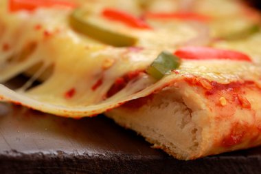 Kırmızı ve yeşil dolmalık biber, soğan, mozzarella peyniri ve ahşap bir tahta üzerine yerleştirilmiş ince hamur hamuru kullanılarak yapılan Paneer Makhani pizzasından pizza çekme.