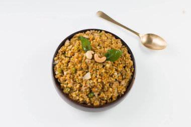 Aval upma ya da poha upma ya da kanda poha upma, çok lezzetli ve pişirmesi kolay olan sağlıklı Hint kahvaltı öğesi ve beyaz desenli arka planlı ahşap bir kasede düzenlenmiştir..