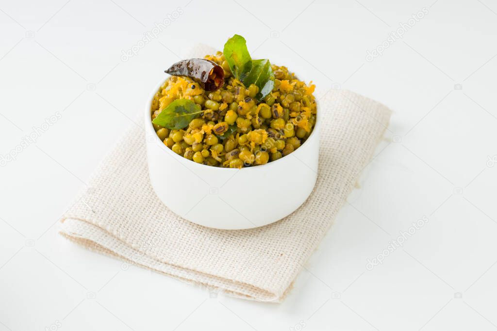 Green gram stir fry or mung bean dry fry,kerala common dish which is very healthy and tasty and it is arranged in a white bowl with white textured background