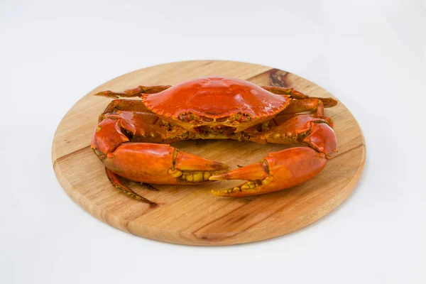 cooked mud crab, arranged on a wooden base with white textured background,top view.