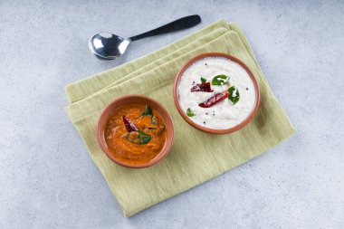 Dosa Chutney _ beyaz hindistan cevizi turşusu ve soğan turşusu, gri desenli arka plan üzerine yerleştirilmiş bir peçeteye yerleştirilmiş..