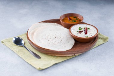 Güney Hindistan geleneksel kahvaltısı Dosa ya da Thattu dosa dökme demir dosa thawa ile yapılmış, yanında beyaz hindistancevizi turşusu ve beyaz dokulu soğan turşusuyla bir sofra takımı ile düzenlenmiş.