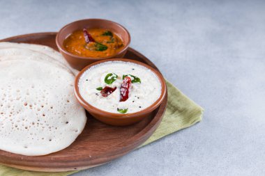 Güney Hindistan geleneksel kahvaltısı Dosa ya da Thattu dosa dökme demir dosa thawa ile yapılmış, yanında beyaz hindistancevizi turşusu ve beyaz dokulu soğan turşusuyla bir sofra takımı ile düzenlenmiş.