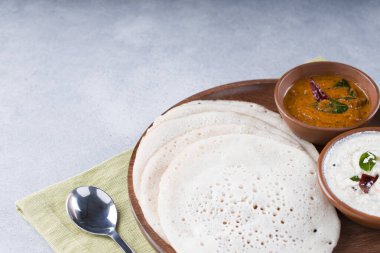 Güney Hindistan geleneksel kahvaltısı Dosa ya da Thattu dosa dökme demir dosa thawa ile yapılmış, yanında beyaz hindistancevizi turşusu ve beyaz dokulu soğan turşusuyla bir sofra takımı ile düzenlenmiş.