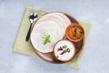 Güney Hindistan geleneksel kahvaltısı Dosa ya da Thattu dosa dökme demir dosa thawa ile yapılmış, yanında beyaz hindistancevizi turşusu ve beyaz dokulu soğan turşusuyla bir sofra takımı ile düzenlenmiş.