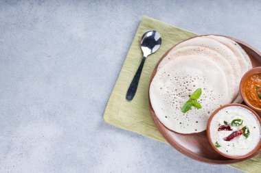 Güney Hindistan geleneksel kahvaltısı Dosa ya da Thattu dosa dökme demir dosa thawa ile yapılmış, yanında beyaz hindistancevizi turşusu ve beyaz dokulu soğan turşusuyla bir sofra takımı ile düzenlenmiş.