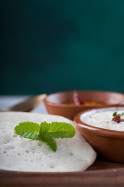 Güney Hindistan geleneksel kahvaltısı Dosa ya da Thattu dosa dökme demir dosa thawa ile yapılmış, yanında hindistancevizi turşusu ve soğan turşusuyla bir sofra takımı ile düzenlenmiş