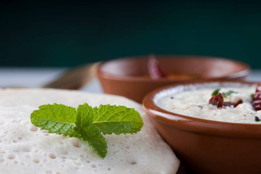 Güney Hindistan geleneksel kahvaltısı Dosa ya da Thattu dosa dökme demir dosa thawa ile yapılmış, yanında hindistancevizi turşusu ve soğan turşusuyla bir sofra takımı ile düzenlenmiş