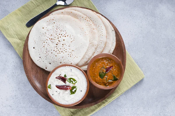 南印度传统早餐多萨或Thattu Dosa 用铁制的多萨或多萨制成 摆放在一个餐具柜中 旁边有白菜 椰子酱和白质背景的洋葱 — 图库照片